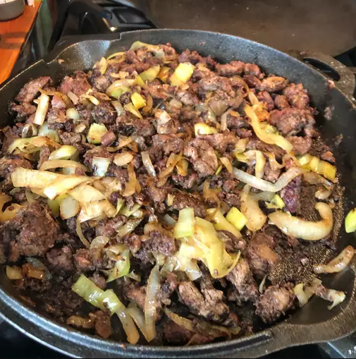 A frying pan filled with beef liver and onions, a popular dish in many cultures around the world. Beef liver and onions are a good source of protein and omega-3 fatty acids, and are also low in calories and fat.